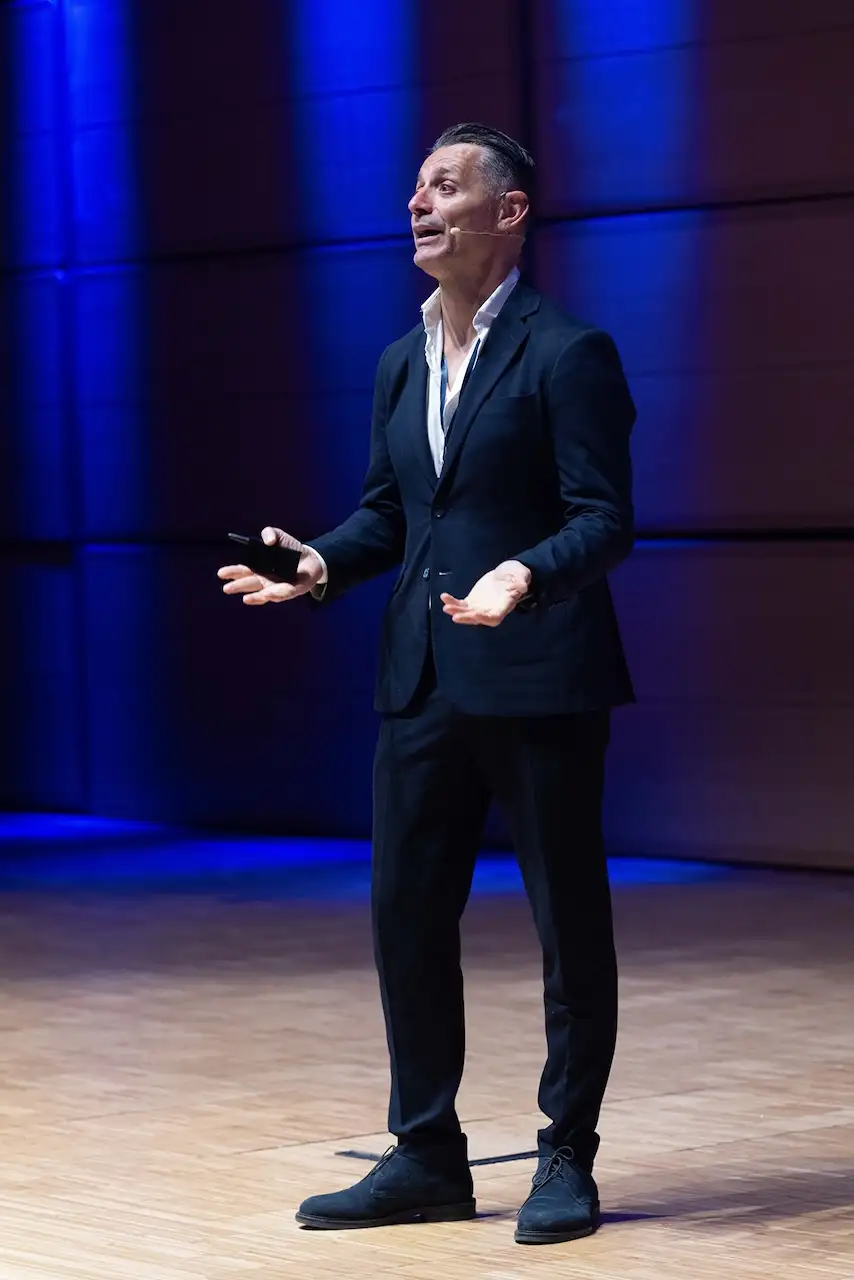 A speaker on stage under blue light